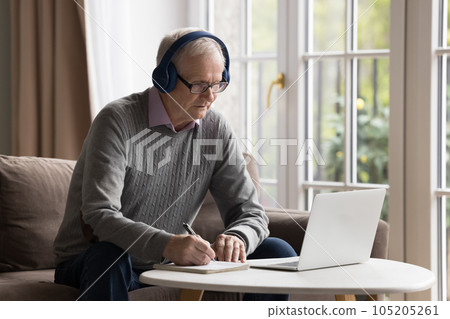 Focused senior man use notebook for online studying at home Focused senior man use notebook for online studying at home 105205261