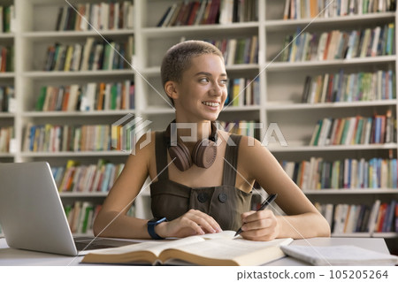 Positive student girl doing academic research study in university library Positive student girl doing academic research study in university library 105205264