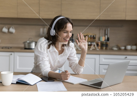 Smiling woman making video call on laptop at home Smiling woman making video call on laptop at home 105205429