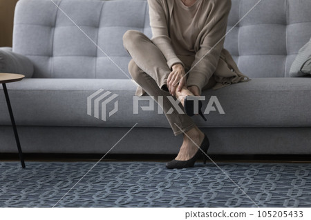Middle aged woman in high heeled shoes taking stiletto off 105205433