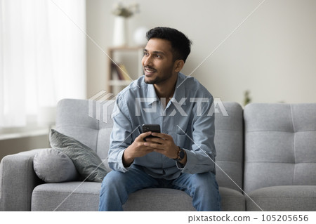 Positive pensive freelance Indian business man enjoying online communication 105205656
