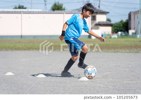 Elementary school boy practicing soccer 105205673