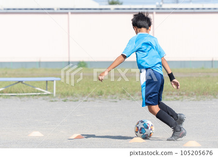 Elementary school boy practicing soccer 105205676