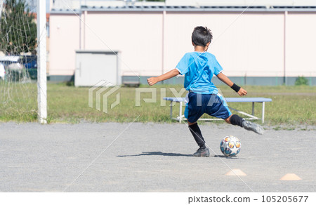 Elementary school boy practicing soccer 105205677