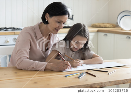 Loving engaged grandma and focused cute girl drawing cartoon sketches 105205716