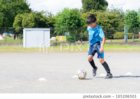 Elementary school boy practicing soccer 105206501