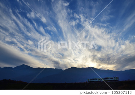 Koumi Line local train silhouetted with clouds flowing over the Southern Alps 105207113