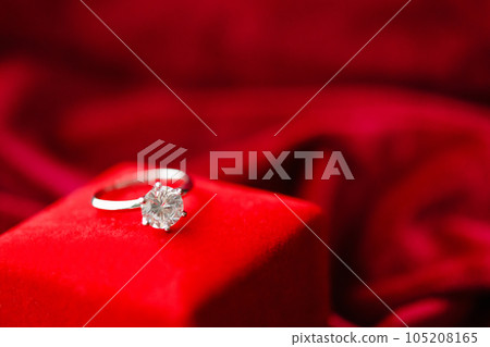 Diamond ring with jewelry gift box on red fabric background 105208165