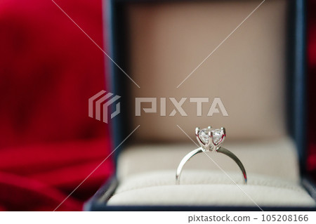 Diamond ring in jewelry gift box on red fabric background 105208166