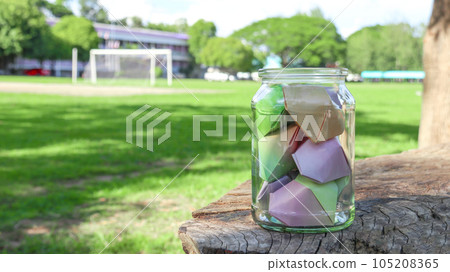 Paper hearts in glass bottles on wooden floor with blurred trees background concept for cheering LGBTQ people around the world                              105208365