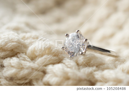 Jewelry diamond ring on knitted fabric background 105208486