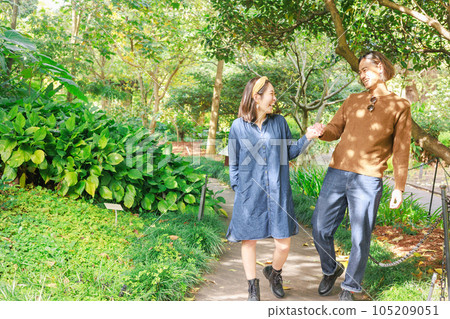 Japanese couple holding hands and laughing in the fresh green Japanese couple holding hands and laughing in the fresh green 105209051
