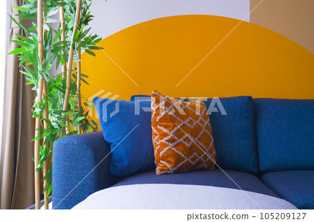 modern blue color sofa with pillows in living room against orange color wall  modern blue color sofa with pillows in living room against orange color wall  105209127