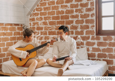 Couple lover concentrate on create a song with guitar and tablet. Couple lover concentrate on create a song with guitar and tablet. 105209200