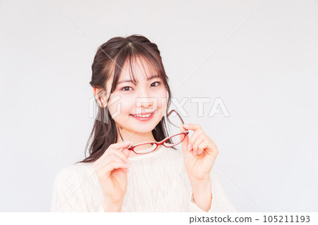 A young woman at an ophthalmologist takes off her glasses for a vision test [ Image of LASIK ] 105211193