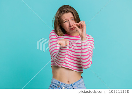 Woman showing a little bit gesture with sceptic smile showing minimum sign measuring small size 105211358