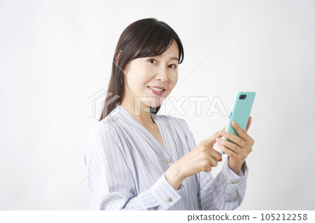 使用智能手機的中年婦女看著相機 105212258