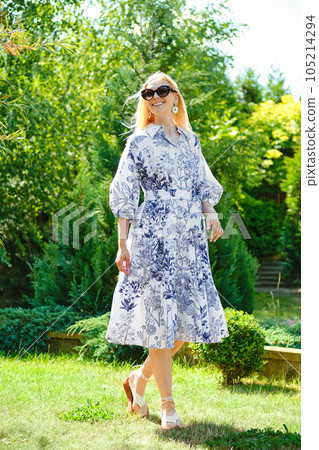 Happy woman in patterned dress on the lawn 105214294
