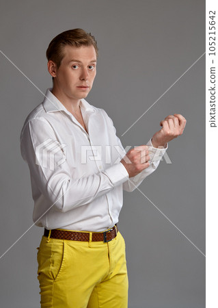 Close-up portrait of a ginger guy in white shirt posing on gray background. Sincere emotions. 105215642