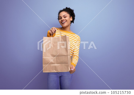 afro brunette latin young woman holding brown craft bag afro brunette latin young woman holding brown craft bag 105215730