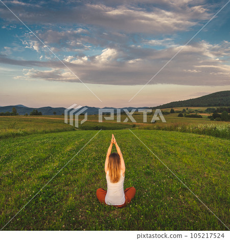 Woman doing yoga on the green grass at the mountain. Carpathians 105217524