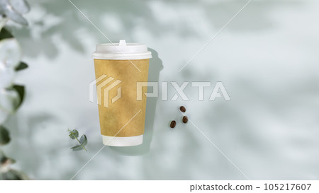 Coffee to go. Spring still life with disposable eco friendly cardboard cup and coffee beans on blue background with eucalyptus leaves and shadows. Takeaway coffee concept. Mockup, flat lay, copy space 105217607