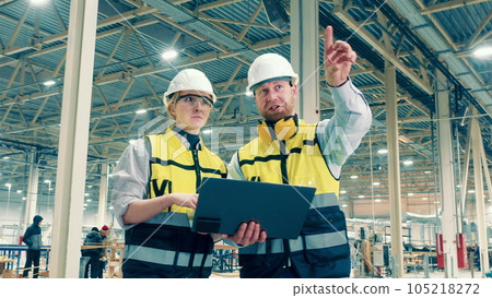 Two factory specialists are smiling while making plans 105218272
