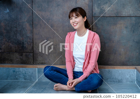 Casual woman sitting on the floor and relaxing 105220412
