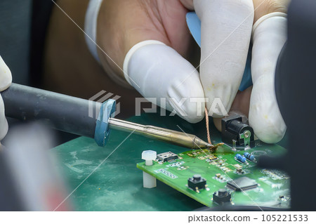 Close up scene the soldering operation by skill operator with rubber finger cot. Close up scene the soldering operation by skill operator with rubber finger cot. 105221533