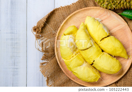 Top view of Durian fruit. Ripe monthong durian on wood plate and white wood background, king of fruit Top view of Durian fruit. Ripe monthong durian on wood plate and white wood background, king of fruit 105222443