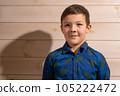 Portrait of a boy 8 years old brunette in a blue shirt. Smiling with closed lips. 105222472