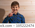 Portrait of a boy 8 years old brunette in a blue shirt. Smiling with closed lips. 105222474