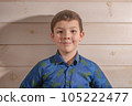 Portrait of a boy 8 years old brunette in a blue shirt. Smiling with closed lips. 105222477
