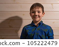 Portrait of a boy 8 years old brunette in a blue shirt. Smiling with closed lips. 105222479