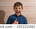 Portrait of a boy 8 years old brunette in a blue shirt. Shows like. 105222482