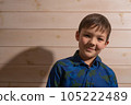 Portrait of a boy 8 years old brunette in a blue shirt. Smiling with closed lips. 105222489