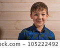 Portrait of a boy 8 years old brunette in a blue shirt. Smiling with closed lips. 105222492