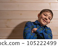 Portrait of a boy 8 years old brunette in a blue shirt. He folded his hands. 105222499