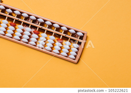 Japanese traditional abacus soroban on orange background. Education and development concept. Back to school, math education, mental mathematics, arithmetic Japanese traditional abacus soroban on orange background. Education and development concept. Back to school, math education, mental mathematics, arithmetic 105222621