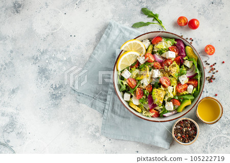 Delicious and healthy green salad of different leaves and vegetables with seeds and olive oil. 105222719