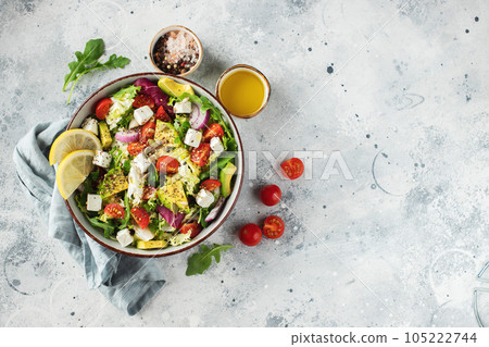 Delicious and healthy green salad of different leaves and vegetables with seeds and olive oil. 105222744