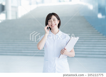 Young female nurse calling by smartphone Young female nurse calling by smartphone 105222775