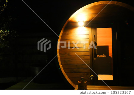Fantastic evening entrance to a stylish private wooden barrel sauna/dry sauna Fantastic evening entrance to a stylish private wooden barrel sauna/dry sauna 105223167