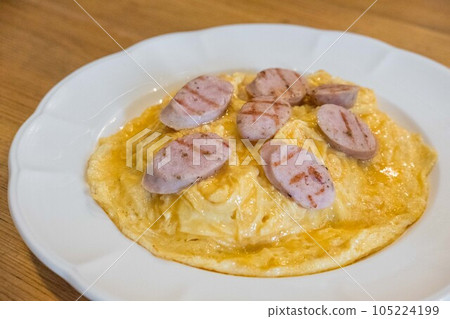 Omelette with sliced sausage served on plate Omelette with sliced sausage served on plate 105224199