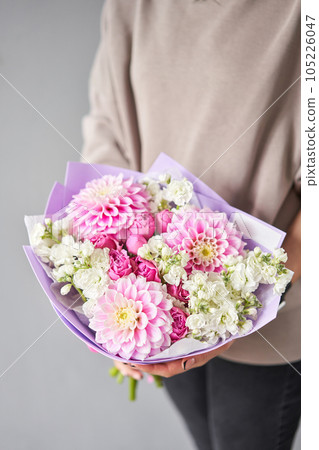 Incredible dahlias are the main flower. Beautiful bouquet of mixed flowers in woman hand. Floral shop concept . Handsome fresh bouquet. Flowers delivery. 105226047