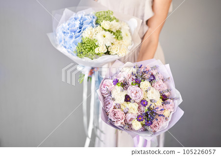 Two Small Beautiful bouquets of mixed flowers in woman hand. Floral shop concept . Beautiful fresh cut bouquet. Flowers delivery Two Small Beautiful bouquets of mixed flowers in woman hand. Floral shop concept . Beautiful fresh cut bouquet. Flowers delivery 105226057