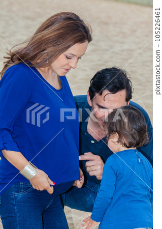 Young couple waiting for their second baby having fun with their baby girl at the beautiful white beach of Lake Tota located in the department of Boyaca at 3,015 meters above sea level in Colombia 105226461
