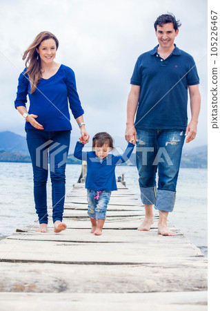 Young couple waiting for their second baby having fun with their baby girl at the beautiful white beach of Lake Tota located in the department of Boyaca at 3,015 meters above sea level in Colombia Young couple waiting for their second baby having fun with their baby girl at the beautiful white beach of Lake Tota located in the department of Boyaca at 3,015 meters above sea level in Colombia 105226467
