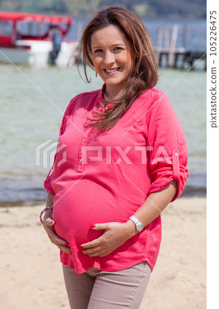 Portrait of a young woman waiting for her baby at the beautiful white beach of Lake Tota located in the department of Boyaca at 3,015 meters above sea level in Colombia 105226475