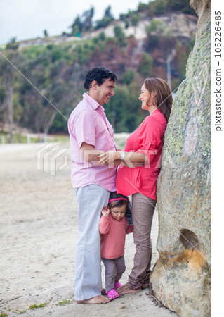 Young couple waiting for their second baby having fun with their baby girl at the beautiful white beach of Lake Tota located in the department of Boyaca at 3,015 meters above sea level in Colombia Young couple waiting for their second baby having fun with their baby girl at the beautiful white beach of Lake Tota located in the department of Boyaca at 3,015 meters above sea level in Colombia 105226485